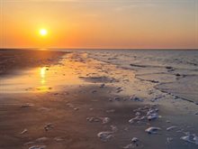 Zonsondergang: oranje lucht en zilver water